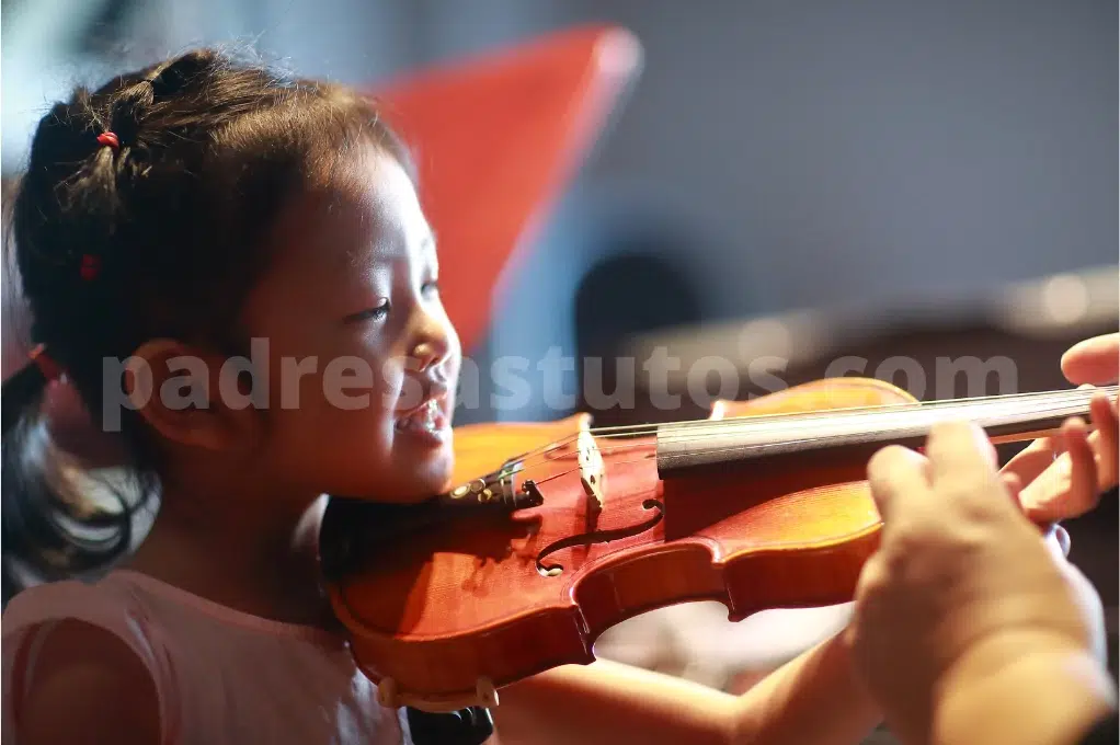 Niña pequeña aprendiendo a tocar el violín.